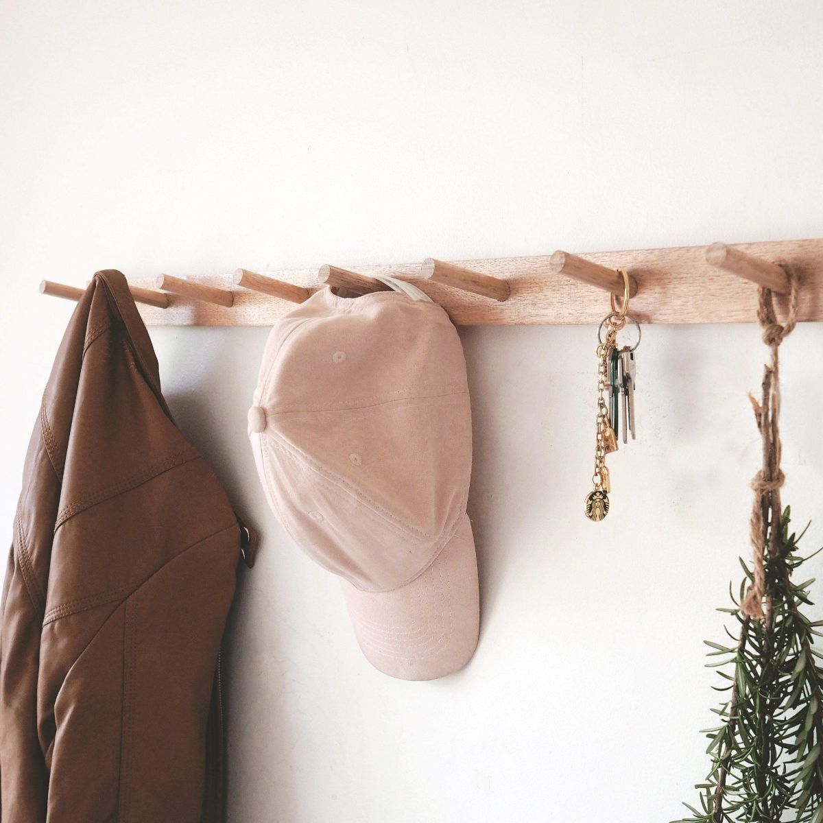 This is a close up view of our Tasmanian Oak Slim Peg Rail or Coat Rack. Brown Jacket, cap and keys are hung on this product