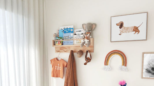 This is a baby's room with a crib, shelf with books and hanging items and change table