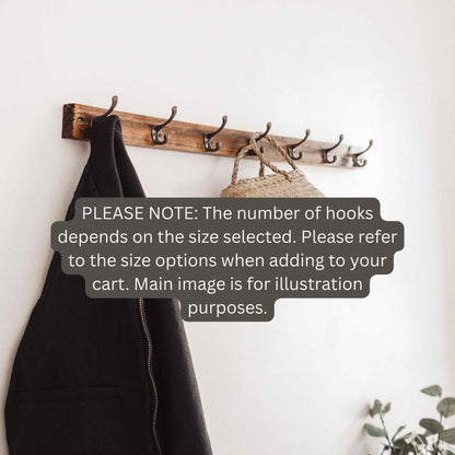 A rustic wooden wall-mounted coat rack with multiple dark metal hooks, shown hanging a black coat and a woven bag against a white wall. A large text overlay explains hook quantity depends on the size selected.