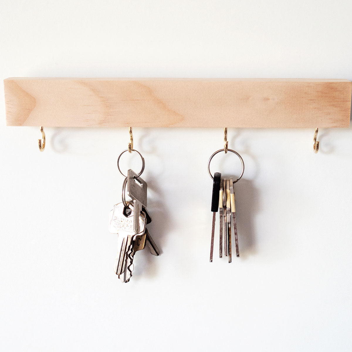 This is a pine wood hook key holder. The hooks are in gold colour