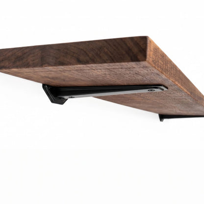 wooden shelf showing black brackets in a white background